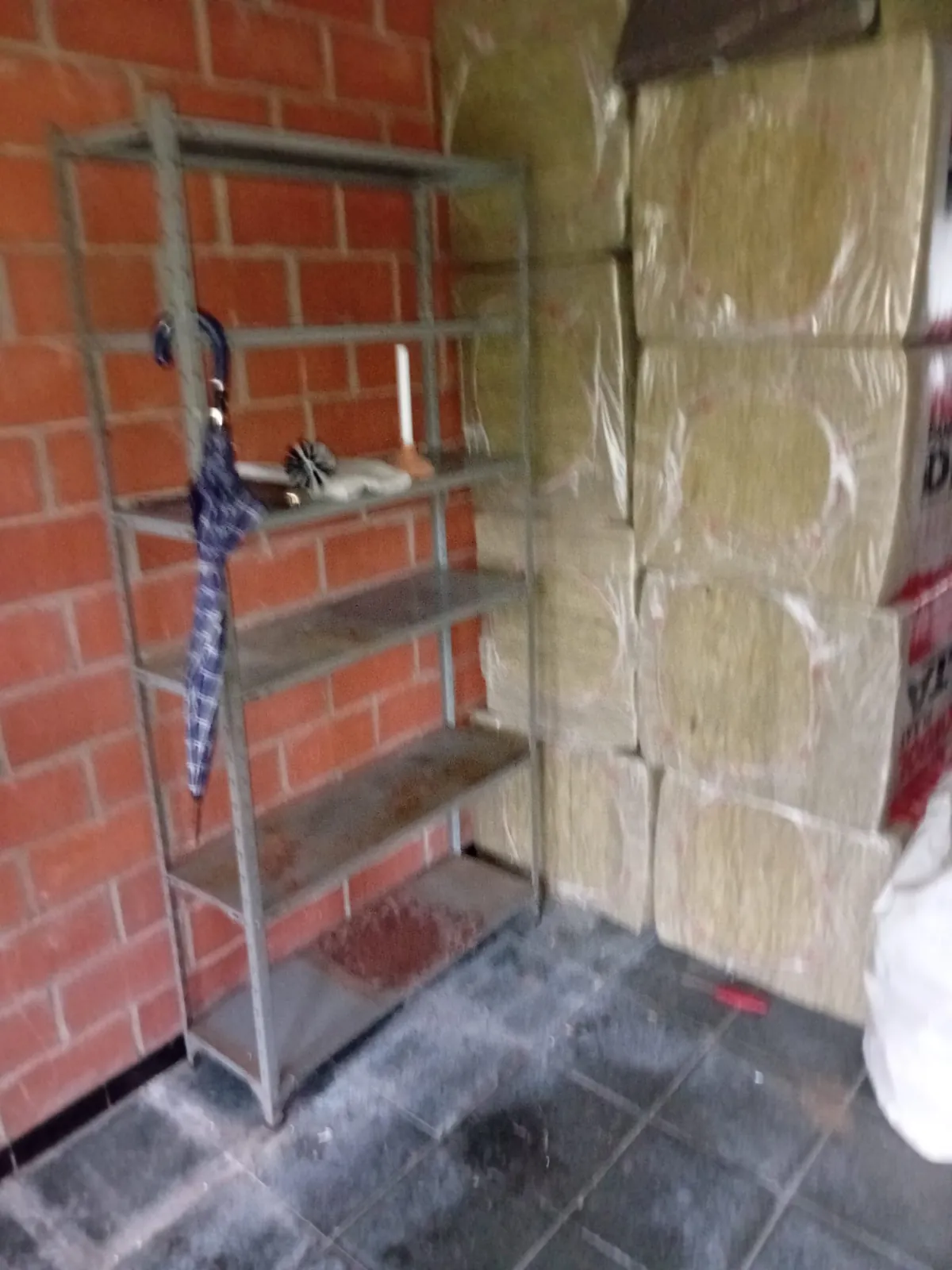 Berging met een metalen rek tegen een bakstenen muur